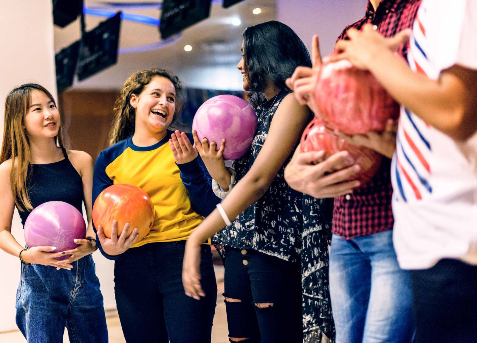 Grupp ungdomar spelar bowling